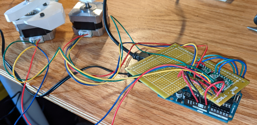 A PCB with wires and motor drivers soldered to it.